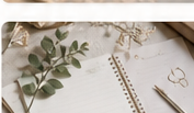 Planner aberto com flores secas, eucalipto e uma caneta dourada